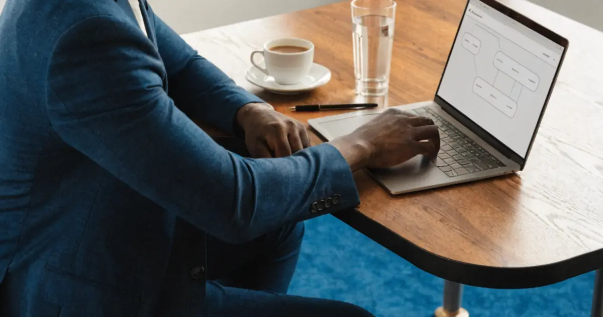A business owner at a conference table reviewing AI workflow outputs on a laptop in a well-lit office
