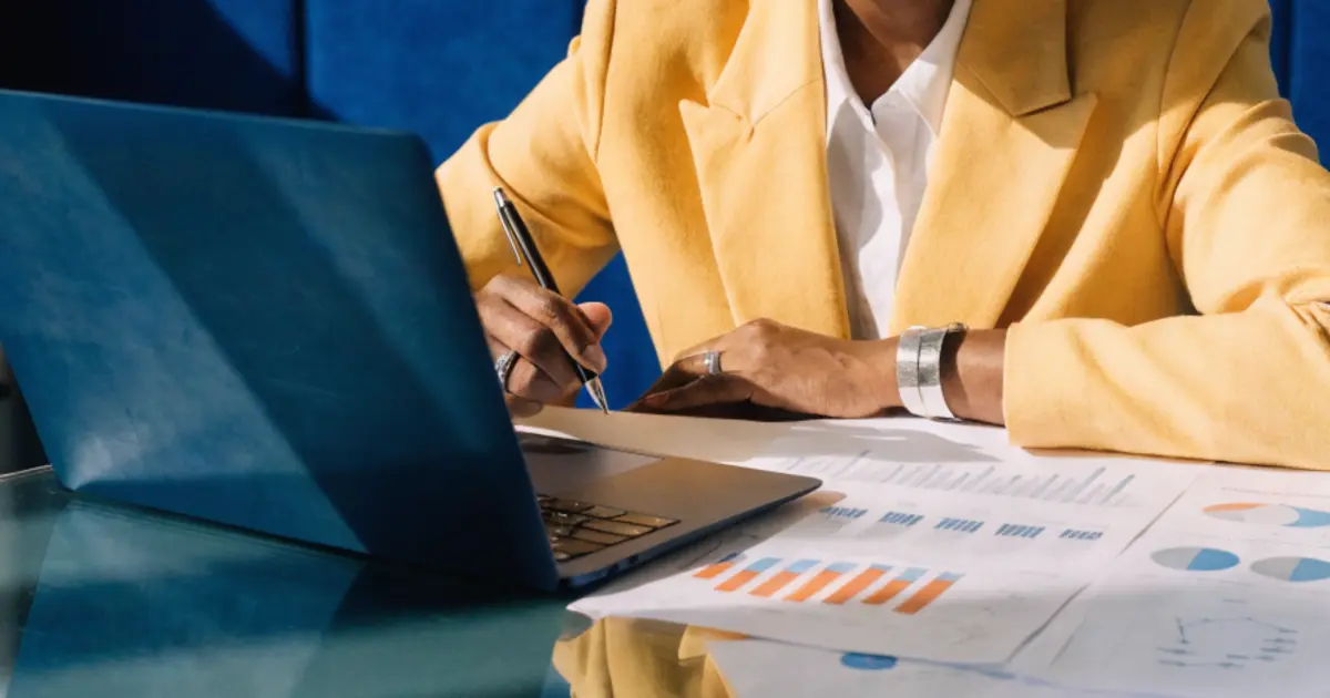 A mid-market business owner reviewing an AI adoption roadmap at a conference table, with printed charts and a laptop open beside her