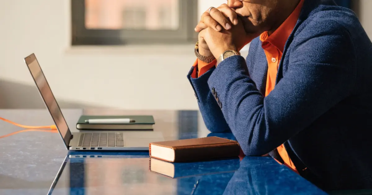 A business owner reviewing an AI implementation roadmap at a conference table, with a Bible and notebook nearby, in warm natural light